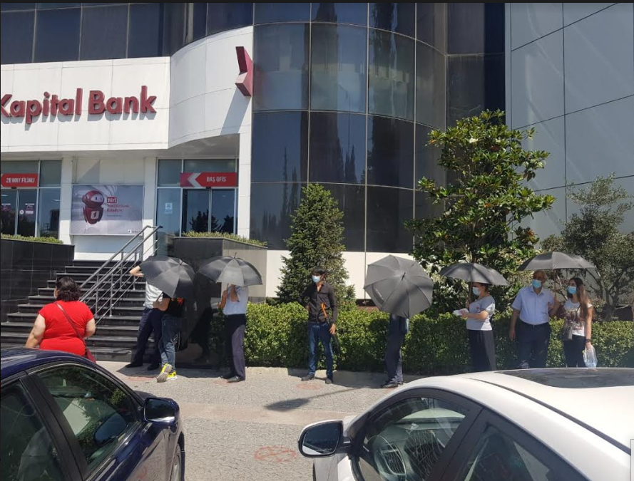 Kapital Bank filialların önündə müştəriləri günvurmadan qoruyur 